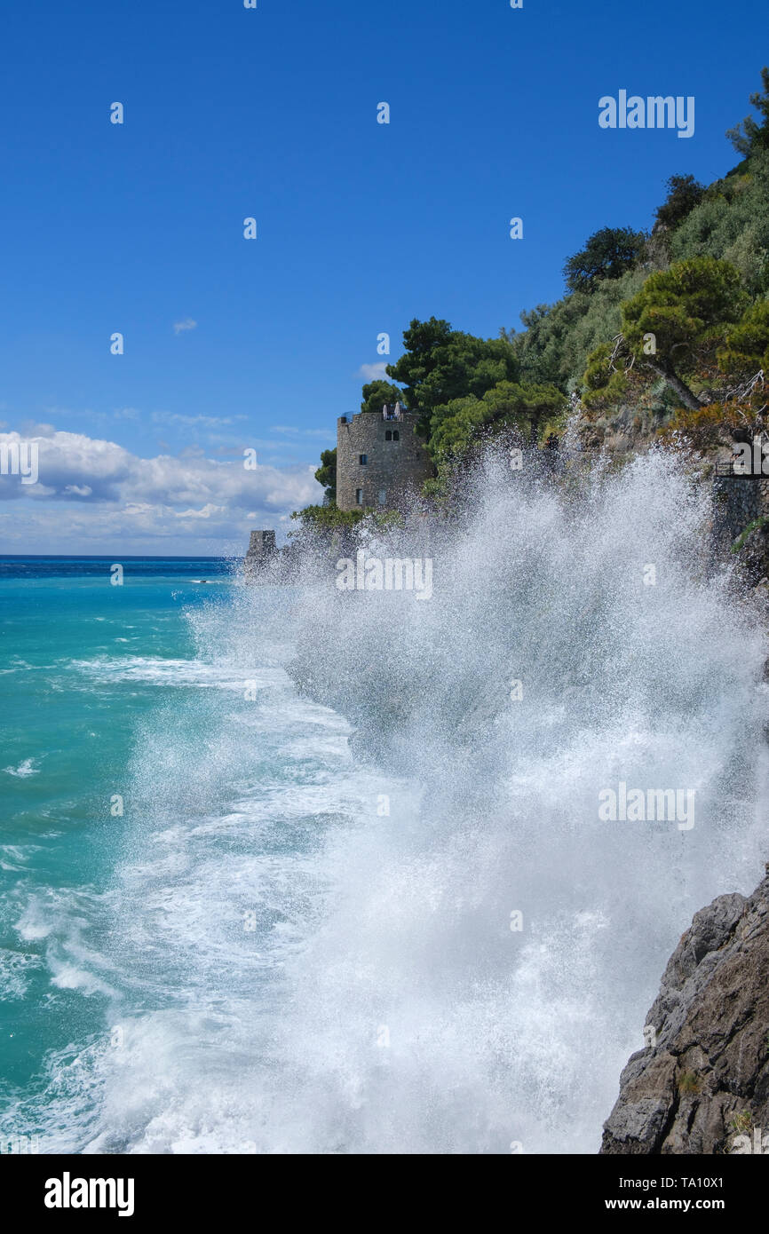 Onde che si infrangono sulla costa scoscesa a sud di Positano sulla Costiera Amalfitana in Campania Italia Meridionale Foto Stock