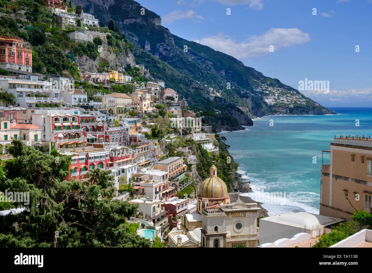 Positano popolare meta di vacanza sulla Costiera Amalfitana in Campania Italia meridionale. La cupola del duomo di Santa Maria Assunta in primo piano. Foto Stock