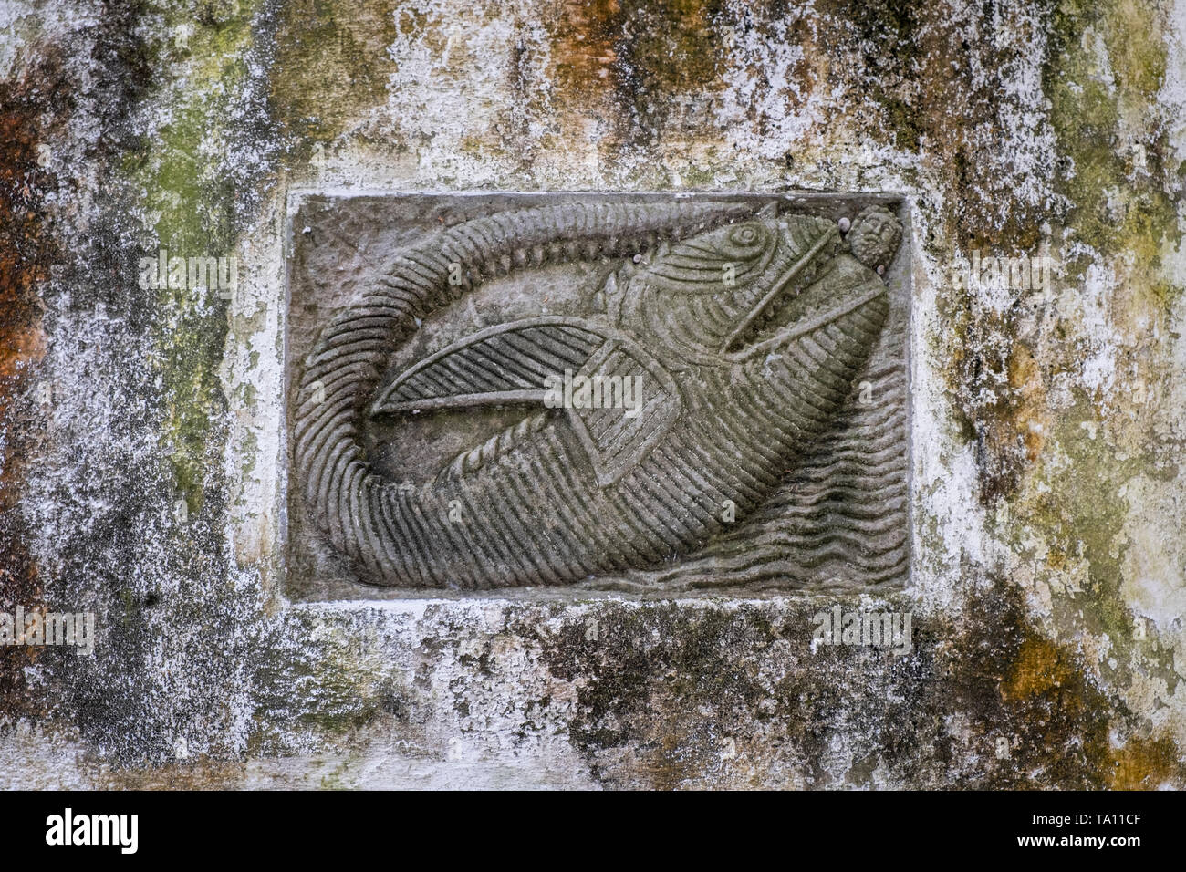 Primitiva arte cattolica un bassorilievo carving di Giona di essere inghiottito da una balena scolpito su un muro di pietra in Amalfi Campania Italia Foto Stock