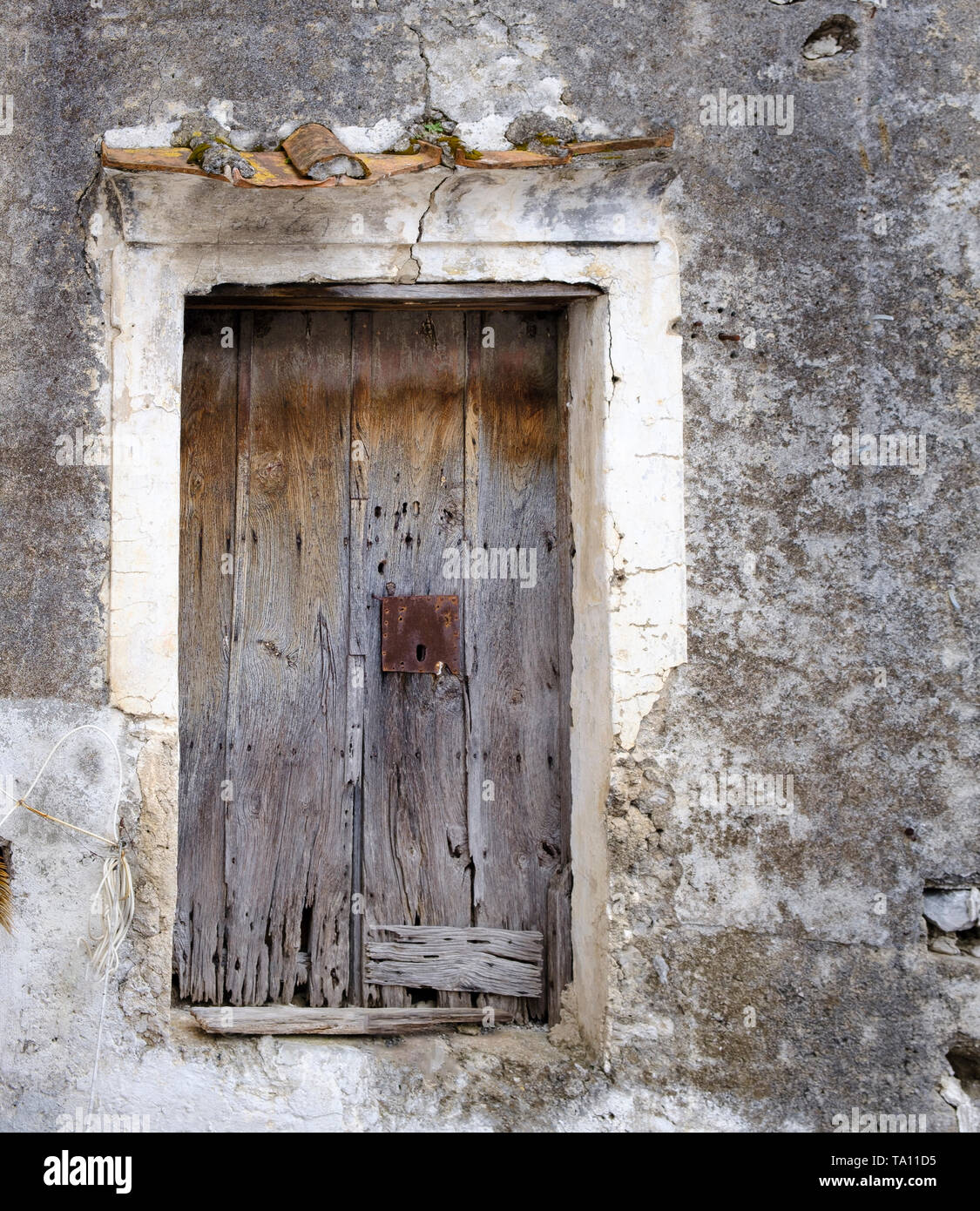 Antica usurati fatiscenti weathered sbiadito porta in legno con serratura arrugginita Foto Stock