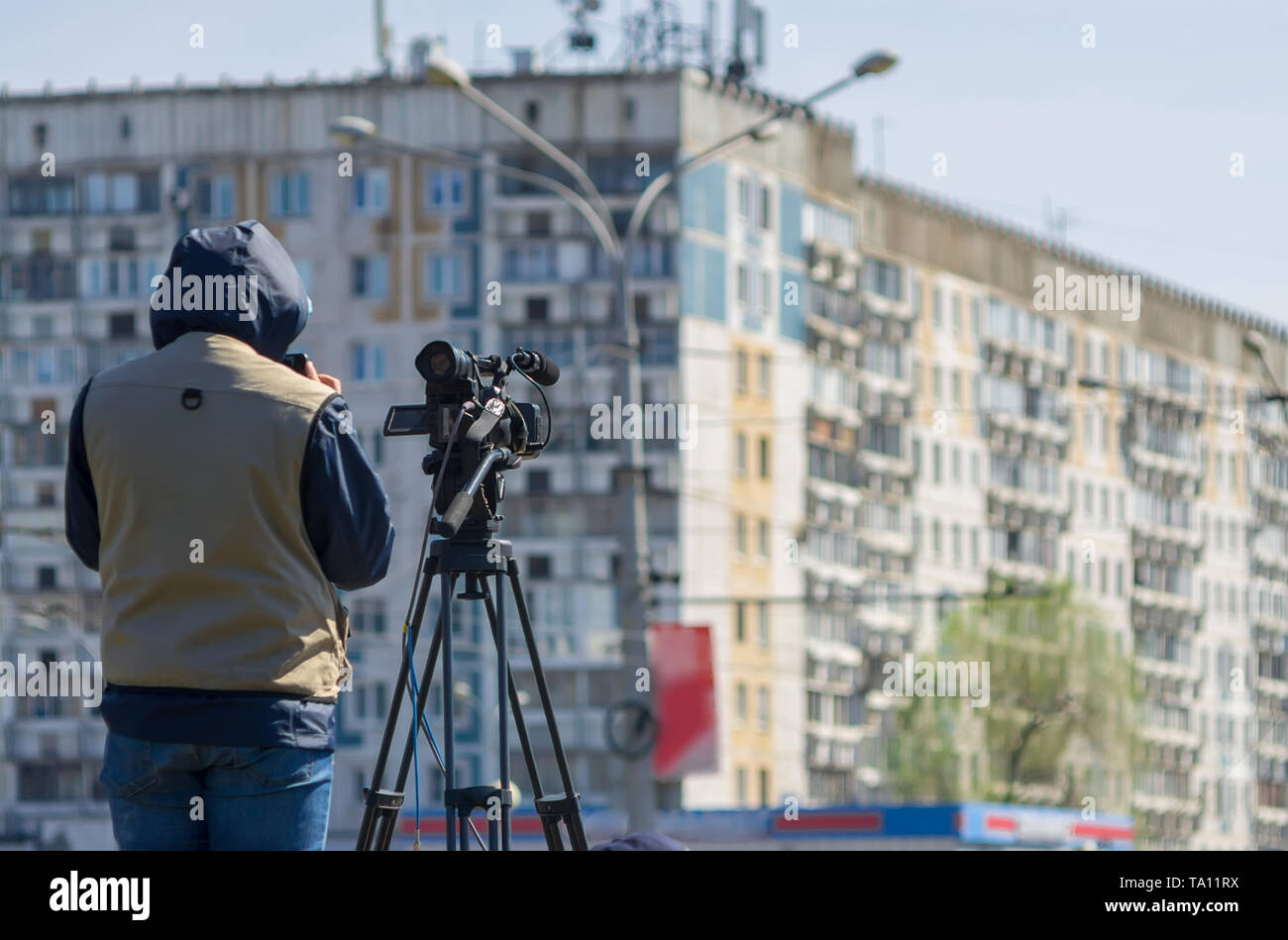 Reporter e cameraman agenzia di notizie su una telecamera professionale spara una relazione sulla piazza della città Foto Stock