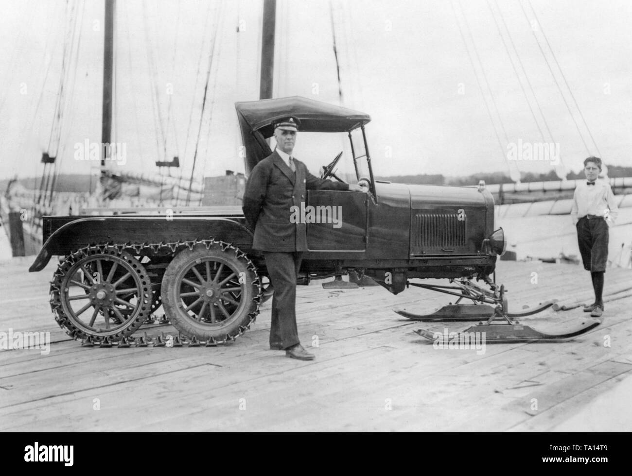 L'Americano esploratore polare Donald MacMillan accanto a una macchina dotata di catene e pattini. Il veicolo si deve sostituire il convenzionale Sled Dog. Foto Stock