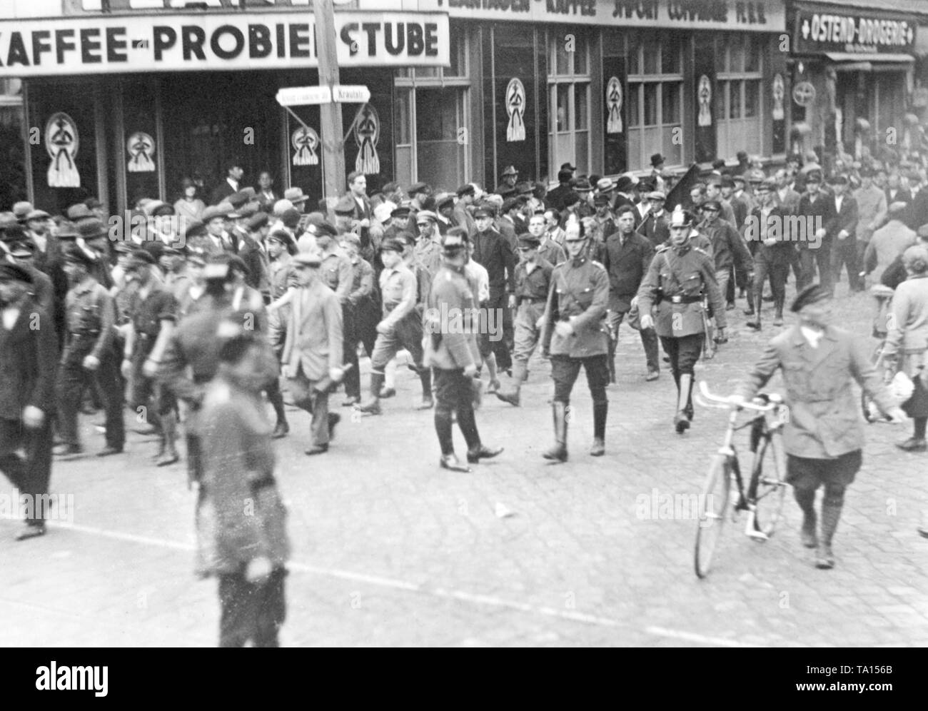 Membri del KPD marzo scortato da poliziotti attraverso le grosse Frankfurter Strasse / Krautstrasse nella direzione di Strausberger Platz. Foto Stock