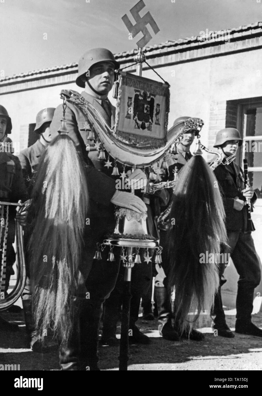 Foto di un membro della banda militare della Legione Condor tenendo una mezzaluna turca (decorata con una croce uncinata e la nazionale spagnola emblema) durante la sfilata in occasione del giorno di celebrazione della Luftwaffe all'aeroporto di Saragozza, Aragon il 1 marzo 1939. Foto Stock