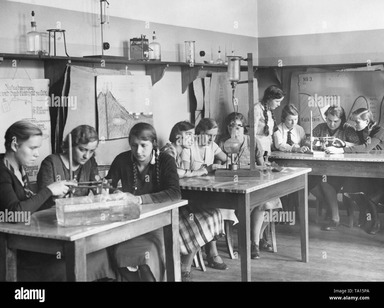 Cercare in una classe durante una classe di fisica a una ragazza della scuola secondaria in Neukoelln. La foto è stata scattata in occasione del XXV anniversario della scuola, probabilmente nel 1932. Foto Stock