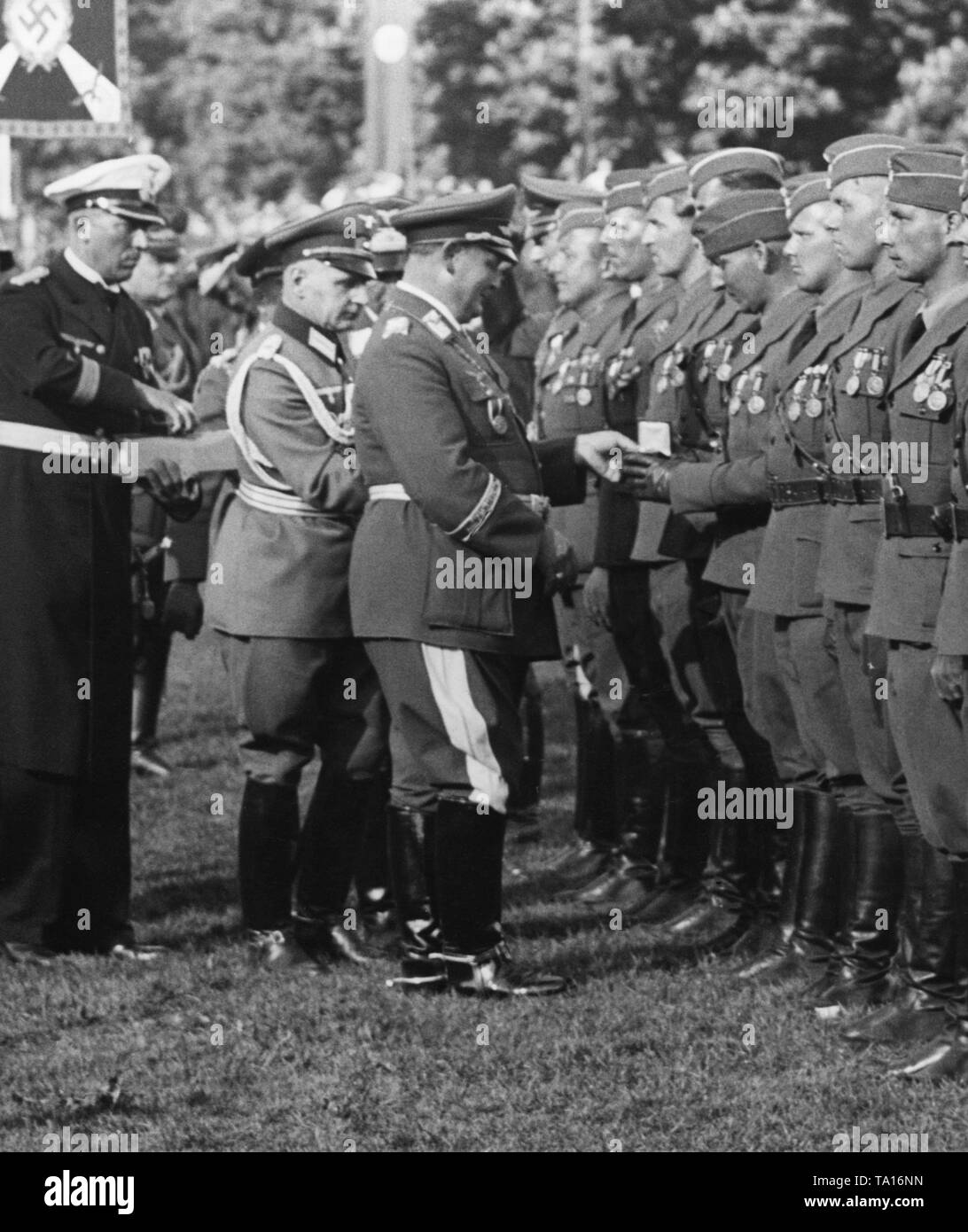 Foto del maresciallo di campo generale Hermann Goering, mentre egli intende aggiudicare gli spagnoli Golden Cross e lo spagnolo della croce dorata con brillants al pilota di ufficiali della Legione Condor, che hanno restituito dalla Spagna, durante una parata di vittoria in Hamburg Moorweide al Dammtor. Gli ufficiali sono già indossando gli spagnoli medaglia militare (sinistra) e la medaglia per la campagna (Medalla de la campana) (sulla destra). Foto Stock