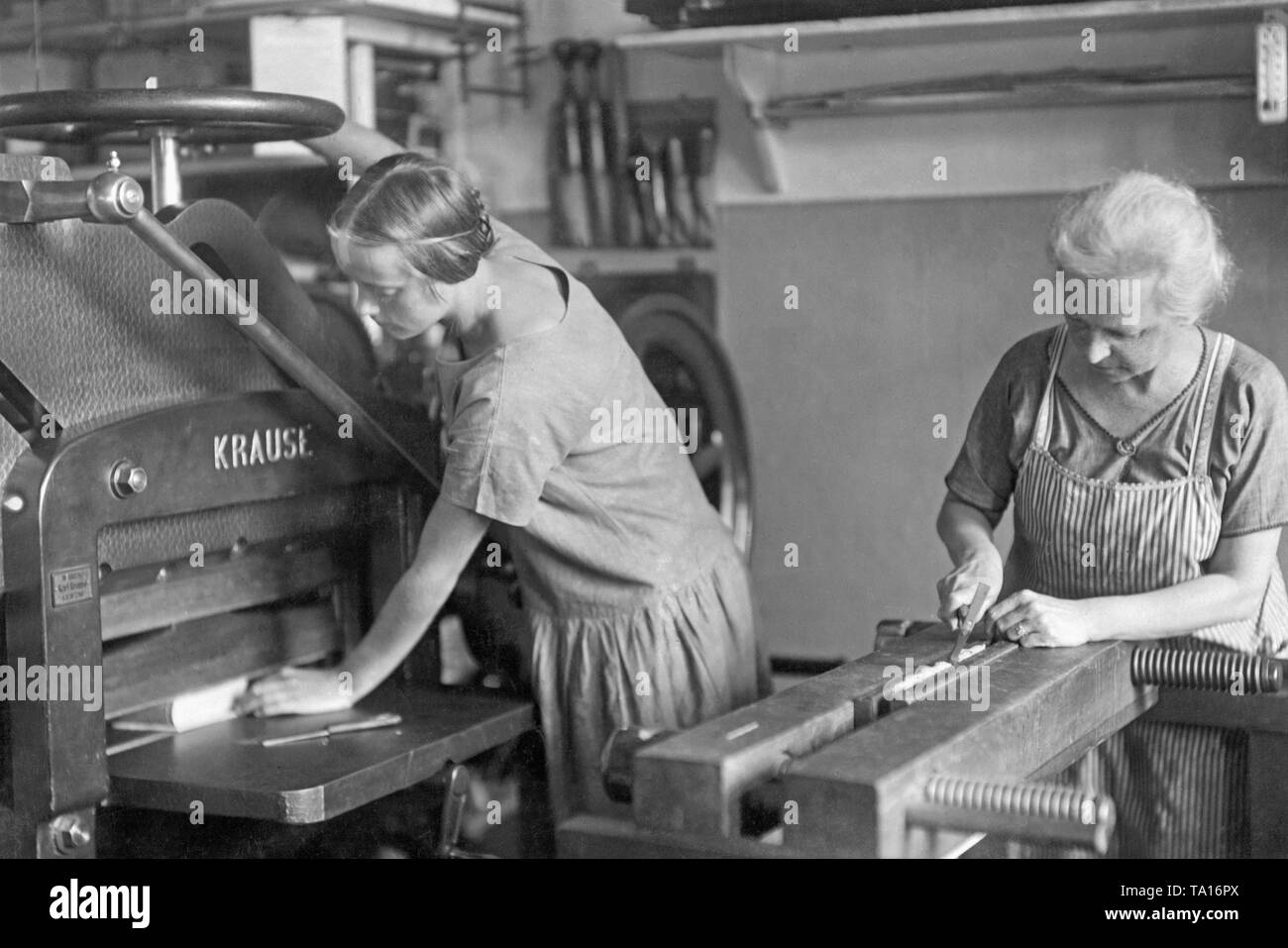 Due donne in un rilegatore di officina nel periodo di Weimar. Nella foto è una macchina da taglio della ditta Karl Krause. Presumibilmente, la foto è stata scattata alla fine degli anni venti. Foto Stock