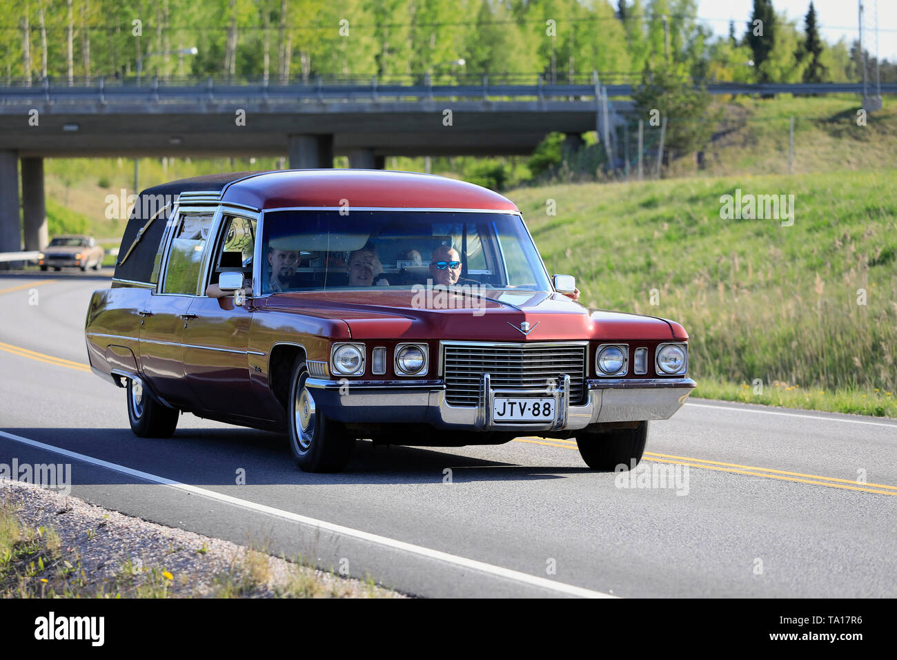 Salo, Finlandia. Maggio 18, 2019. Vintage Cadillac auto funebre in colore marrone rossiccio si muove lungo la strada rurale sul salone di crociera Maisema 2019. Foto Stock