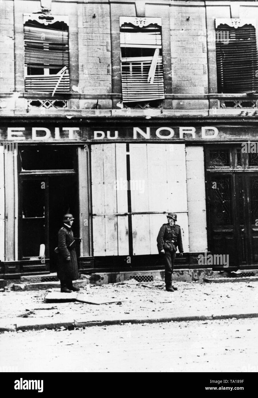 I soldati della Wehrmacht sostare davanti a un negozio di rovina etichettato 'Edit du Nord' a Sedan. Maggio 1940, foto: corrispondente di guerra Kindermann. Foto Stock