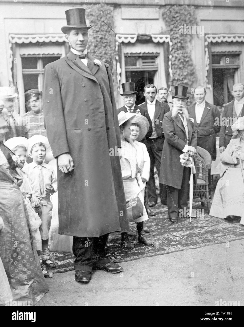 Il gigante russo Feodor Machnow, a quel tempo uomo più alto del mondo, si introduce per i bambini a una festa in giardino nella Cancelleria del Reich a Berlino. Foto Stock