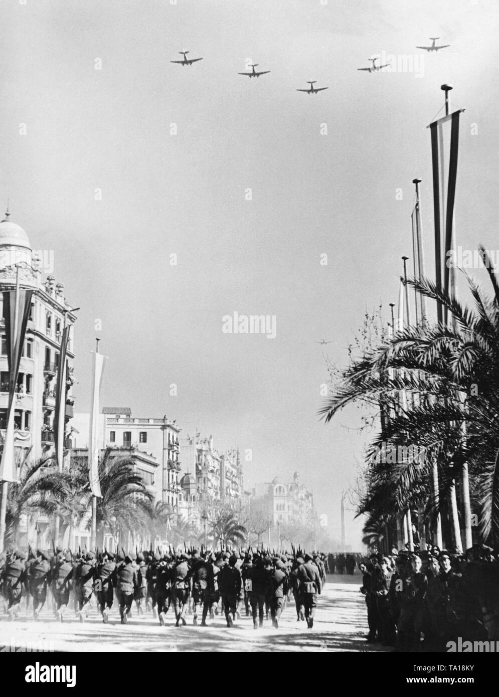 Foto di una parata di vittoria della nazionale spagnola di unità sul Passeig de Colon dopo la conquista (gennaio 1939) di Barcellona dal generale Francisco Franco in febbraio, 1939. In primo piano, marching le unità di fanteria. Nel cielo, formazione di volo il tedesco della Legione Condor. Foto Stock