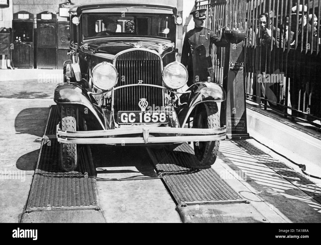 I freni di un automobile sono testati in una riparazione auto negozio di Londra. Per questo, l'unità di auto su una piattaforma e viene frenato bruscamente. Misurata la forza di frenatura può essere quindi leggere la colonna sul lato destro dell'immagine. Foto Stock