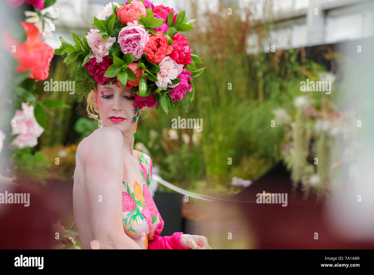 Un modello di visto indossare un display floreale con cappello di arte del corpo in posa per i fotografi durante il Chelsea flower show. Il Royal Horticultural Society Chelsea Flower Show è un giardino annuali mostrano che oltre cinque giorni nella motivazione del Royal Hospital Chelsea nella zona ovest di Londra. La mostra è aperta al pubblico dal 21 maggio fino al 25 maggio 2019. Foto Stock