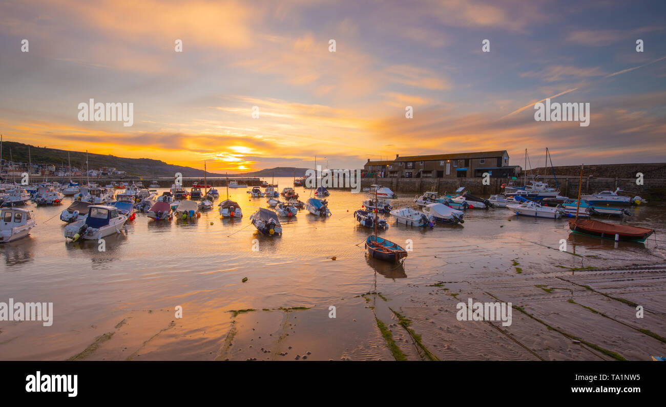 Lyme Regis, Dorset, Regno Unito. 22 maggio 2019. Regno Unito Meteo: Moody sunrise di colori a bassa marea a Cobb a Lyme Regis. Credito: Celia McMahon/Alamy Live News. Foto Stock
