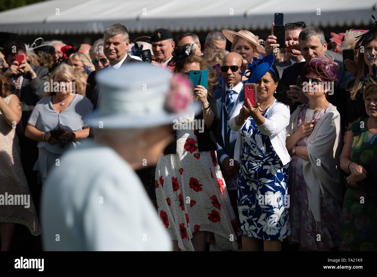 Gli ospiti di prendere le foto della Regina Elisabetta II durante il Royal Garden Party a Buckingham Palace a Londra. Foto Stock