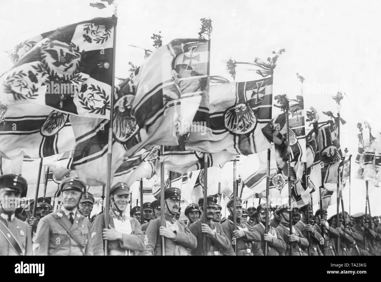 Una compagnia di bandiera a una sfilata sul campo di Tempelhof di Berlino. Molti portano una Reichskriegsflagge con loro. Foto Stock