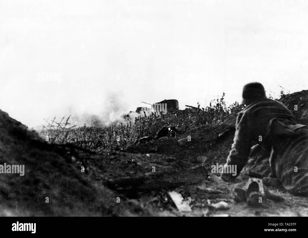 Un soldato tedesco tenta di strisciare vicino ai carri armati sovietici. Un serbatoio è già acceso, mentre gli altri continuano a funzionare. Apparentemente è un britannico "Churchill' serbatoio. Foto di Propaganda Company (PK): corrispondente di guerra Schmidt. Foto Stock