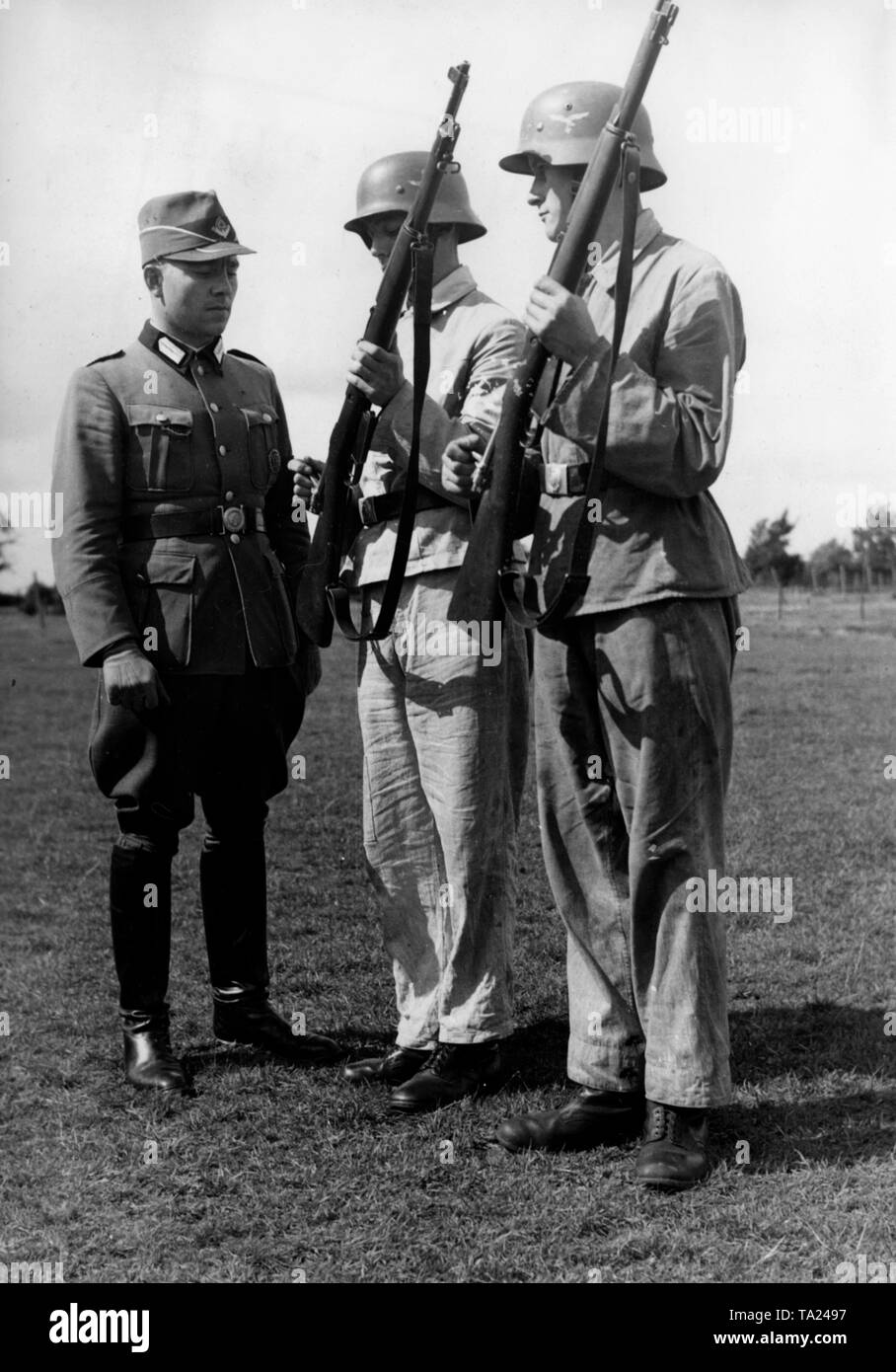 Reich Servizio del lavoro agli uomini presenti i loro fucili (belga Mauser moschettone, modello 1889/36 o M.1936) al loro Feldmeister (foreman). Foto Stock