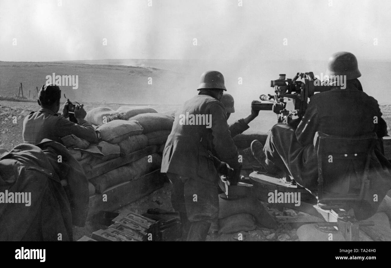 Foto non datata di una unità antiaerea della Legione Condor durante il dispiegamento nella guerra civile spagnola. Due uomini mirano a bersagli di terra con un 2cm FLAK 39 in una posizione di contrappeso. A sinistra nella parte anteriore ci sono le casse di munizioni. I soldati sono indossando M35 elmetti di acciaio. Foto Stock