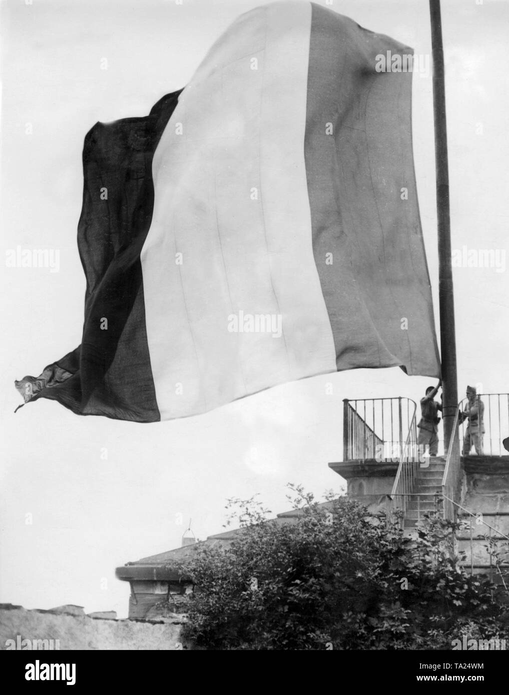 Due membri dell'occupazione francese vigore abbassare la bandiera della Francia. Foto Stock