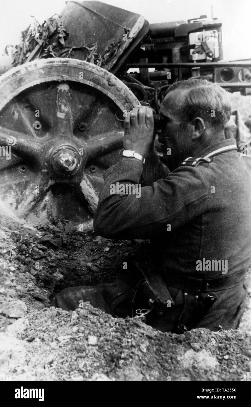 Un soldato tedesco orologi il nemico posizioni da un fucile pit. Accanto a lui un antitank gun (presumibilmente una 7.5 cm PaK-40). Foto di Propaganda Company (PK): corrispondente di guerra Kraayvanger. Foto Stock