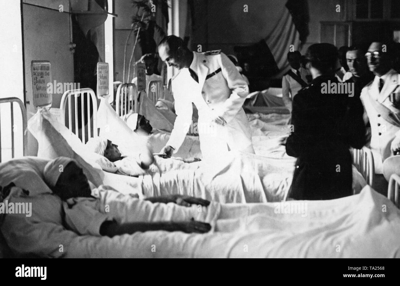 Foto italiano del principe ereditario Umberto (1946, come Umberto II ultimo re d'Italia, in bianco uniforme) visitando soldati feriti dalla guerra civile spagnola in un ospedale di Napoli, Campania. Foto Stock