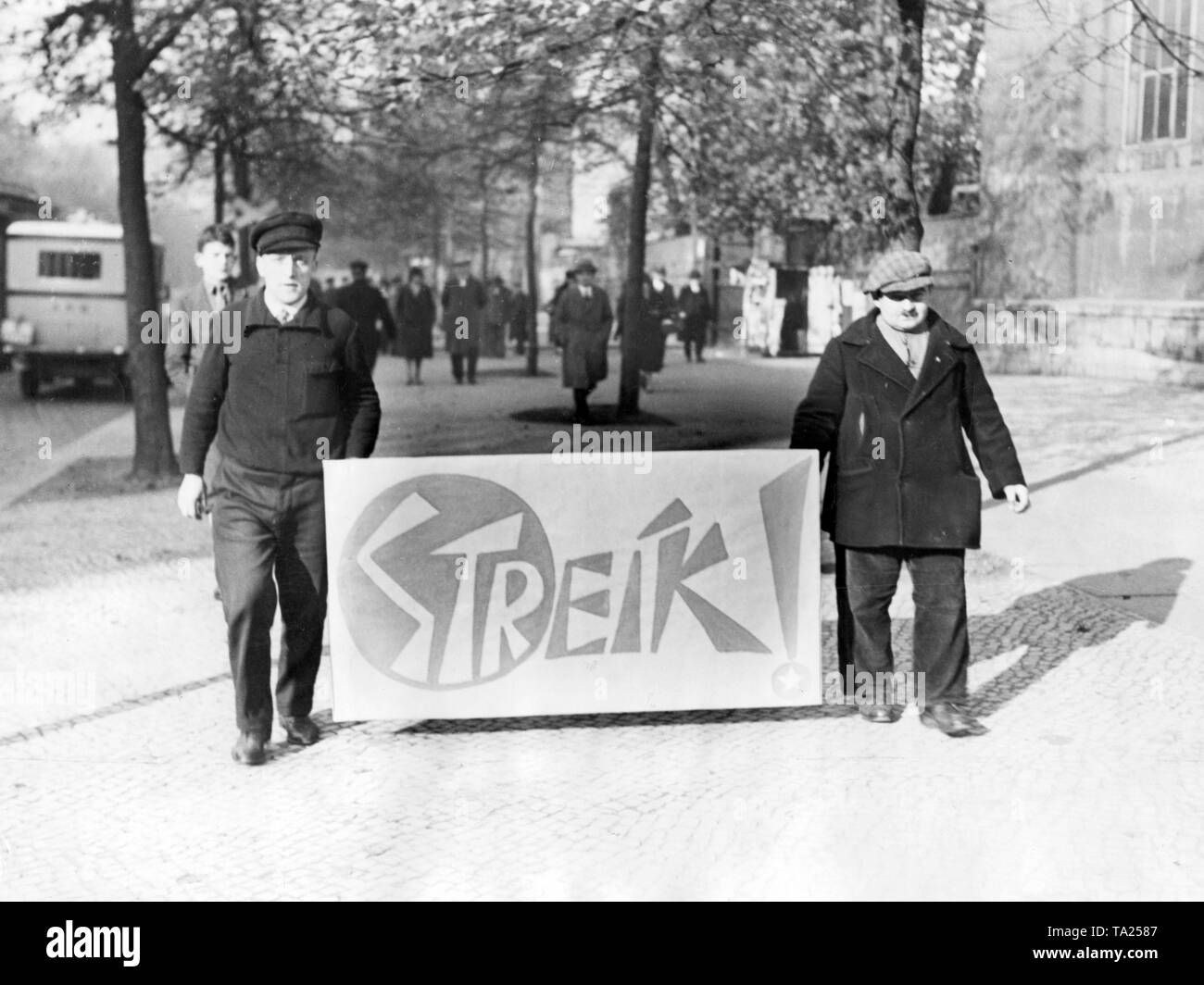 In ottobre 1930, il metallo di Berlino chiamato trust per uno sciopero. Qui ci sono due percussori con il loro poster che mostrano la loro parola d'ordine. Foto Stock