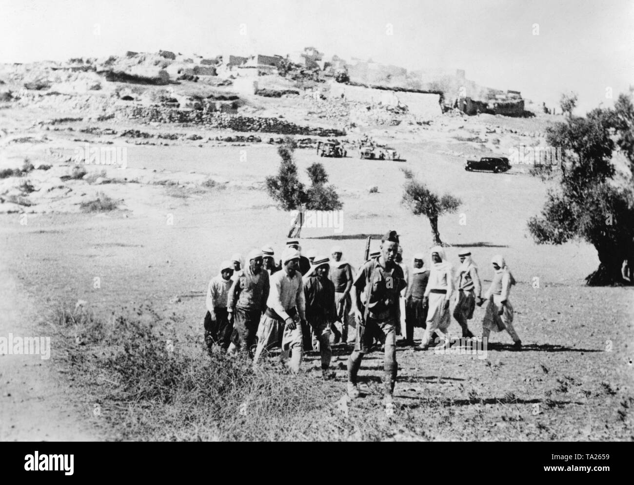 Un soldato britannico porta i prigionieri politici durante la insurrezione araba di lavorare in un campo nel nord oggi in Israele. Foto Stock