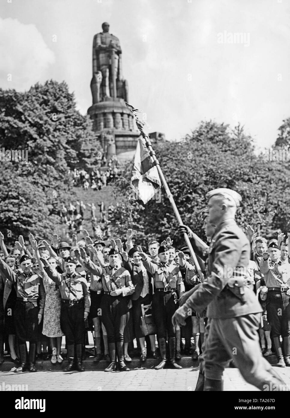 La testa della parata (con standard) della Legione Condor marching presso il monumento di Bismarck in Alter Elbpark Millerntorplatz a. In precedenza, i soldati sono arrivati con le navi della flotta KdF nel porto di Amburgo (passerelle). Membri della Gioventù Hitleriana e dei passanti mostrano il saluto di Hitler sul ciglio della strada. Foto Stock