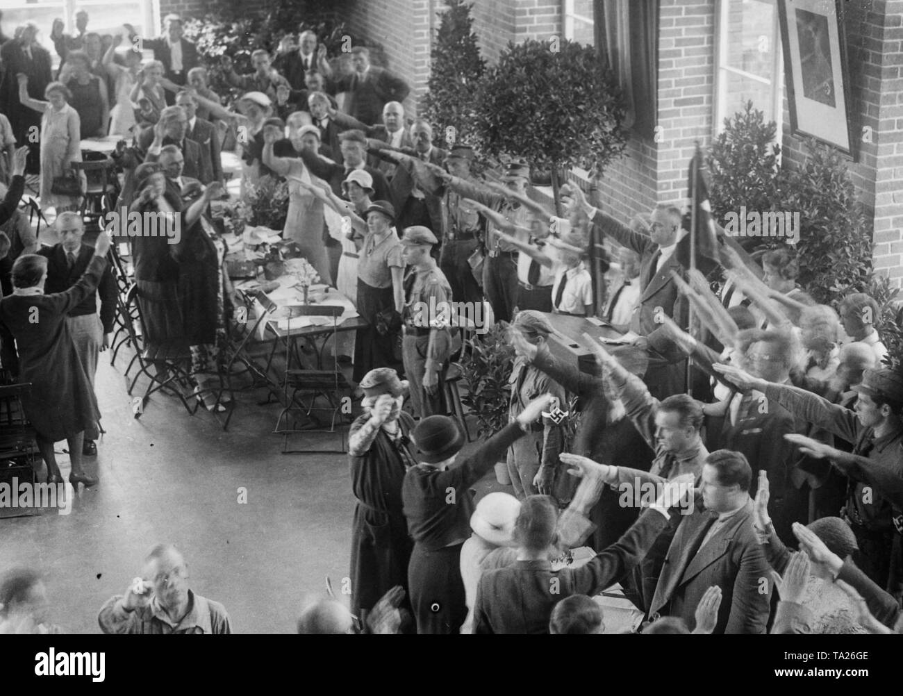 Il sindaco di Berlin-Weissensee, Ernst Neumann (al leggio), apre una cucina del benessere del NS-Volkswohlfahrt nella Volksschule in Parkstrasse (Weissensee) di Berlino. Panoramica delle cerimonie di apertura durante l'inno nazionale. Sulla parete di destra un ritratto di Adolf Hitler. Foto non datata. Foto Stock