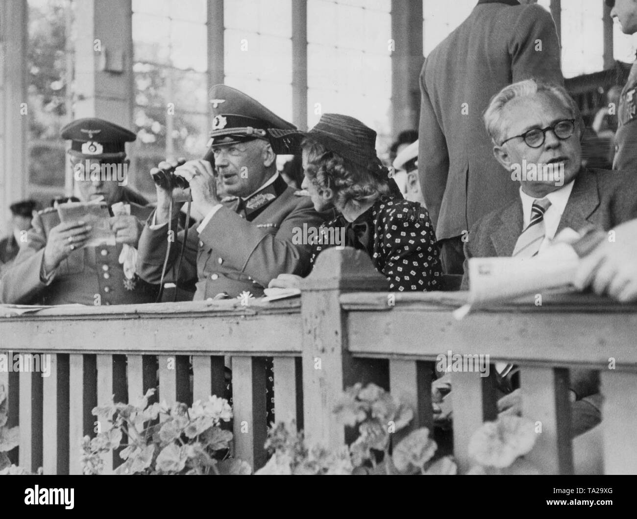Il comandante del distretto militare VII di Baviera Edmund Wachenfeld (medio) insieme con Hitler personale del fotografo Heinrich Hoffmann (destra) in stand durante la corsa dei cavalli in Riem. Foto Stock