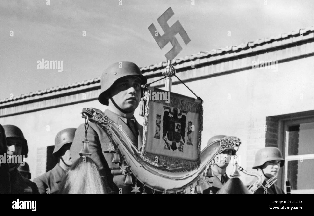 Foto di un membro della banda militare della Legione Condor tenendo una mezzaluna turca (decorata con una croce uncinata e la nazionale spagnola emblema) durante la sfilata in occasione del giorno di celebrazione della Luftwaffe all'aeroporto di Saragozza, Aragona su marzo il 1st, 1939. Foto Stock
