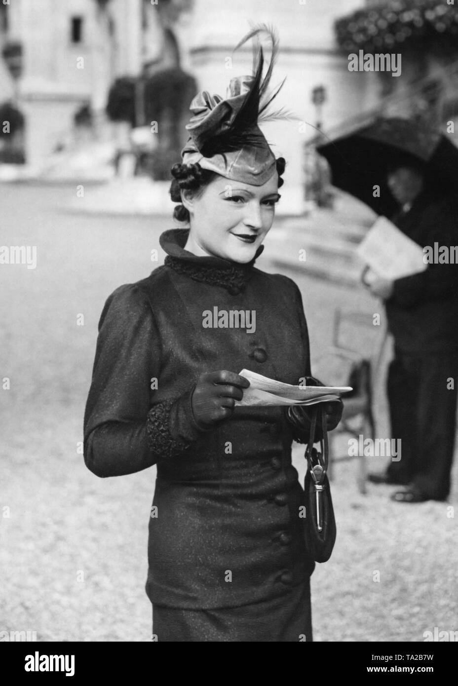 Donna che indossa un cappello con piume dalla collezione autunno al cavallo di razza in via "Longchamp'. Foto Stock