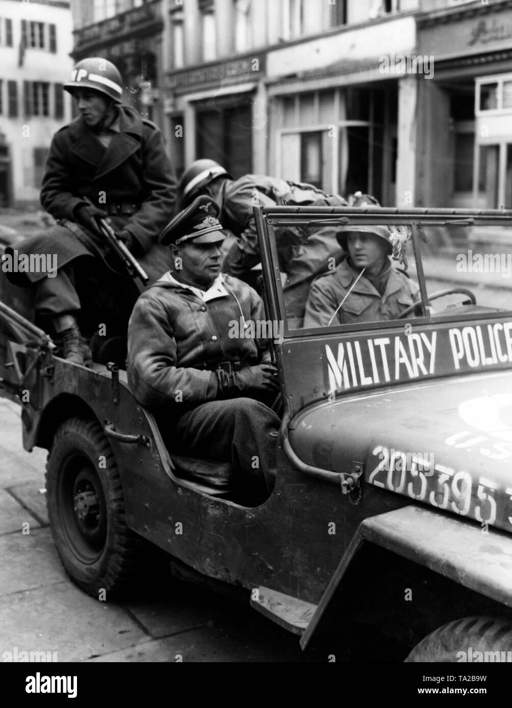 I militari americani poliziotti tenere lontano il funzionario Henke nella loro jeep, che era stato catturato lungo l'autostrada di Ansbach insieme con un centinaio di altri soldati tedeschi. Foto Stock