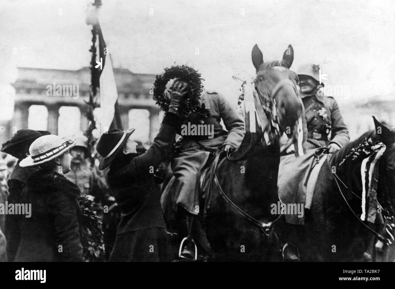 Un passante mette una corona attorno al collo di un soldato proveniente dalla guerra. Egli appartiene alla trentasettesima divisione di fanteria che, dopo l'armistizio di Compiègne, ha dato la sua posizione sul fronte occidentale a marzo torna in Germania. Foto Stock Un passante mette una corona attorno al collo di un soldato proveniente dalla guerra. Egli appartiene alla trentasettesima divisione di fanteria che, dopo l'armistizio di Compiègne, ha dato la sua posizione sul fronte occidentale a marzo torna in Germania. Foto Stock