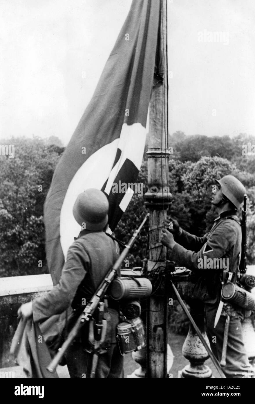 I soldati della Wehrmacht issare la bandiera con la svastica sul Castello Reale di Laken vicino a Bruxelles in Belgio. La città di Bruxelles è stato consegnato senza una lotta in maggio 17, 1940. Foto: corrispondente di guerra Wittek. Foto Stock