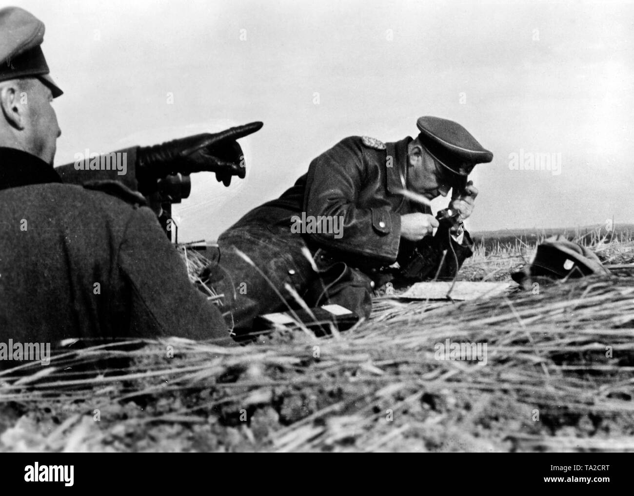 Un generale (eventualmente il tenente generale Erich Schopper, comandante della 81st divisione di fanteria) utilizza una lente di ingrandimento per lo studio di una mappa dell'area. Un altro generale (eventualmente anche un funzionario) punti con un dito in corrispondenza di una posizione in zona. Foto di Propaganda Company (PK): corrispondente di guerra Hanfland. Foto Stock Un generale (eventualmente il tenente generale Erich Schopper, comandante della 81st divisione di fanteria) utilizza una lente di ingrandimento per lo studio di una mappa dell'area. Un altro generale (eventualmente anche un funzionario) punti con un dito in corrispondenza di una posizione in zona. Foto di Propaganda Company (PK): corrispondente di guerra Hanfland. Foto Stock