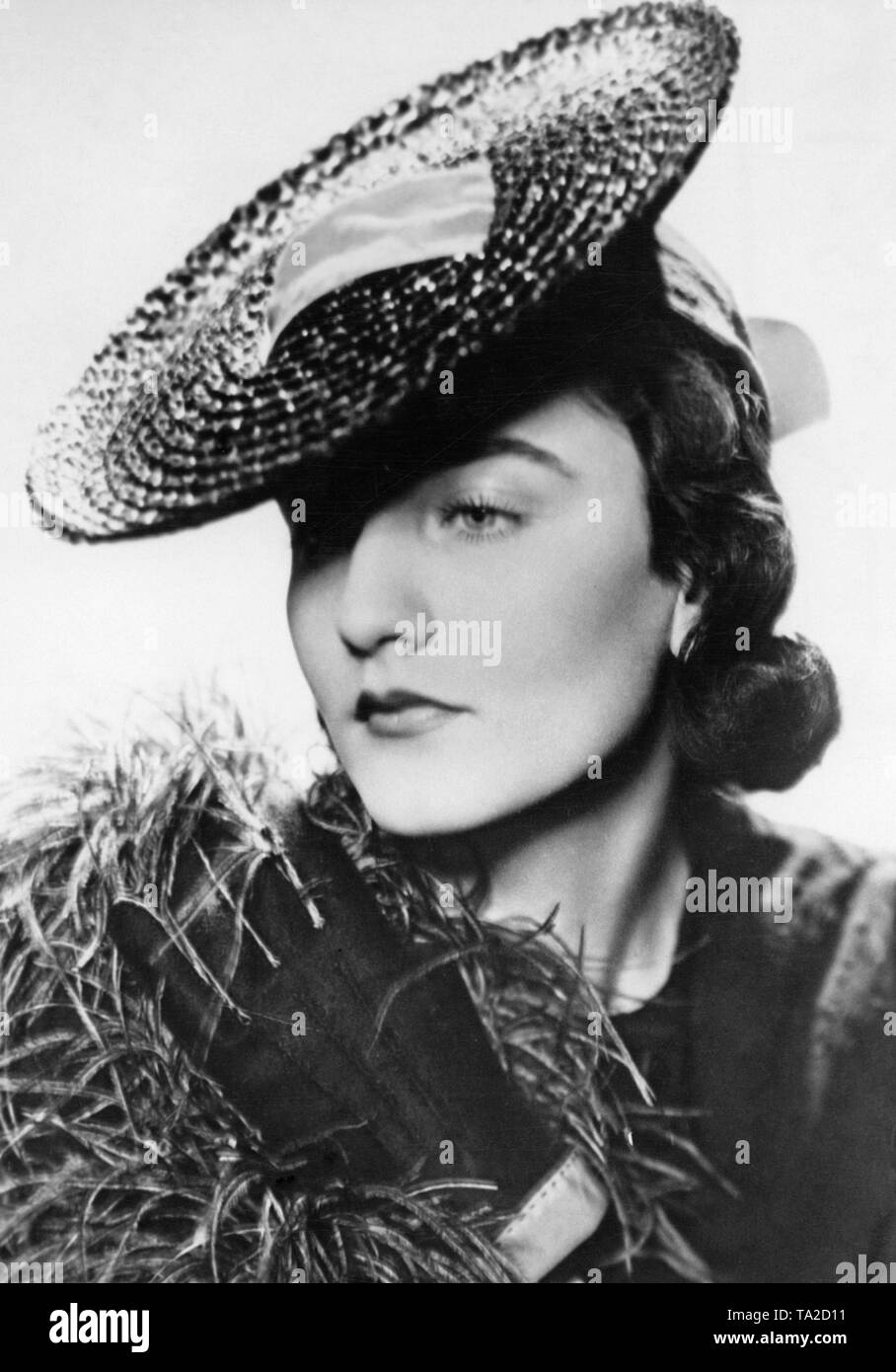 Modello in un quartiere alla moda di hat, moda per l'estate del 1938: il nero cappello di paglia. Foto Stock