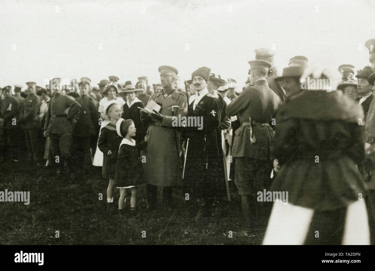 Il comandante del "ferro" Divisione Grandi Josef Bischoff (centro, con documento in mano e "Pour le Merite" medaglia intorno al collo) e il comandante del West Esercito di Liberazione Russo, Principe Pavel Mikhailovich Bermondt-Avaloff (destra accanto a Bischoff, con croce ortodossa sulla manica sinistra) circondato da soldati ma anche le donne e i bambini. Foto Stock