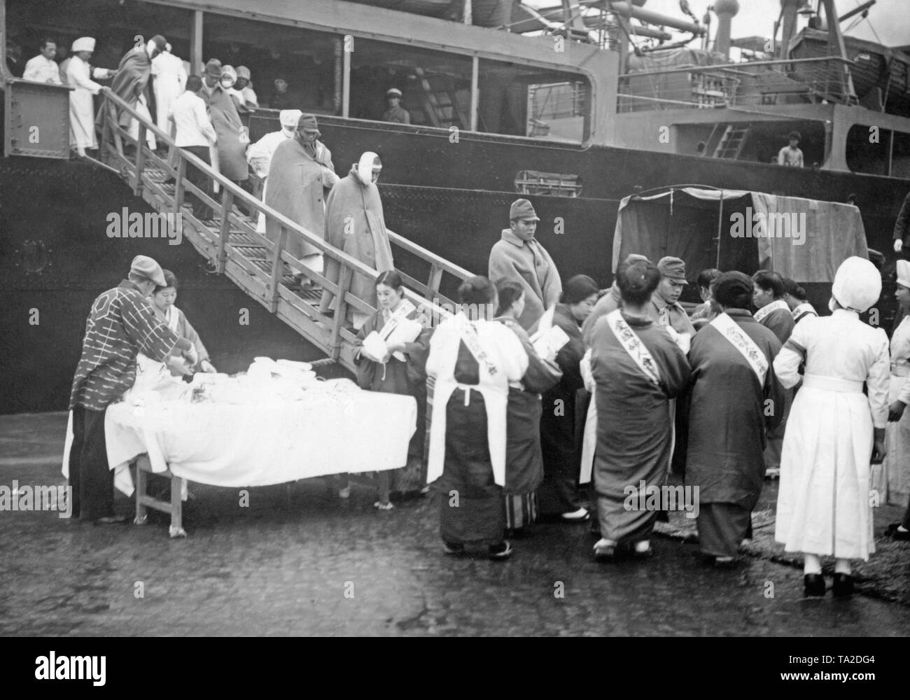 I soldati feriti della Seconda Guerra Japanese-Chinese andando a Tokyo dalla nave ospedale Hagami Maru. Essi sono ricevuti da infermieri. Foto Stock