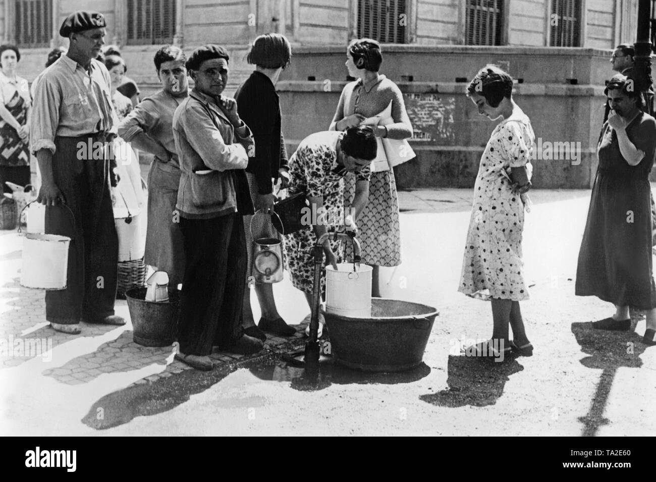Un gruppo di civili stand in coda presso un pubblico bene per acqua potabile. Poco prima della conquista in settembre il nazionalista spagnolo truppe riuscì a tagliare Sann Sebastian dall'acqua di alimentazione. Foto Stock