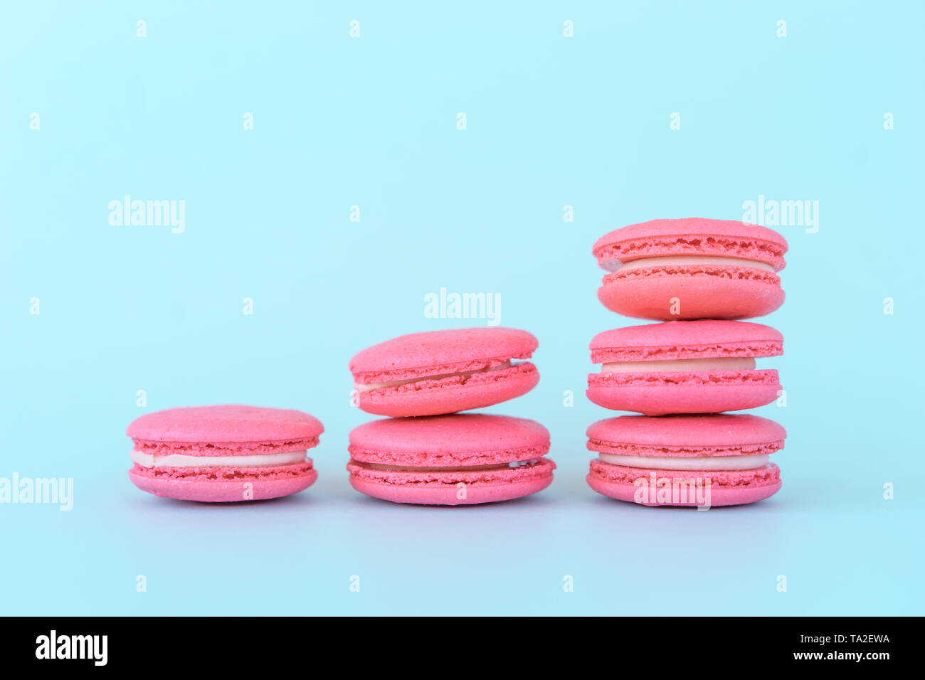 Amaretti rosa su sfondo blu. Concetti di classificazione e di crescita. Foto Stock