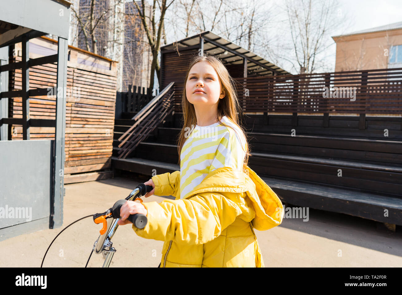 Bella ragazza teen in un paesaggio urbano con uno scooter. Foto Stock