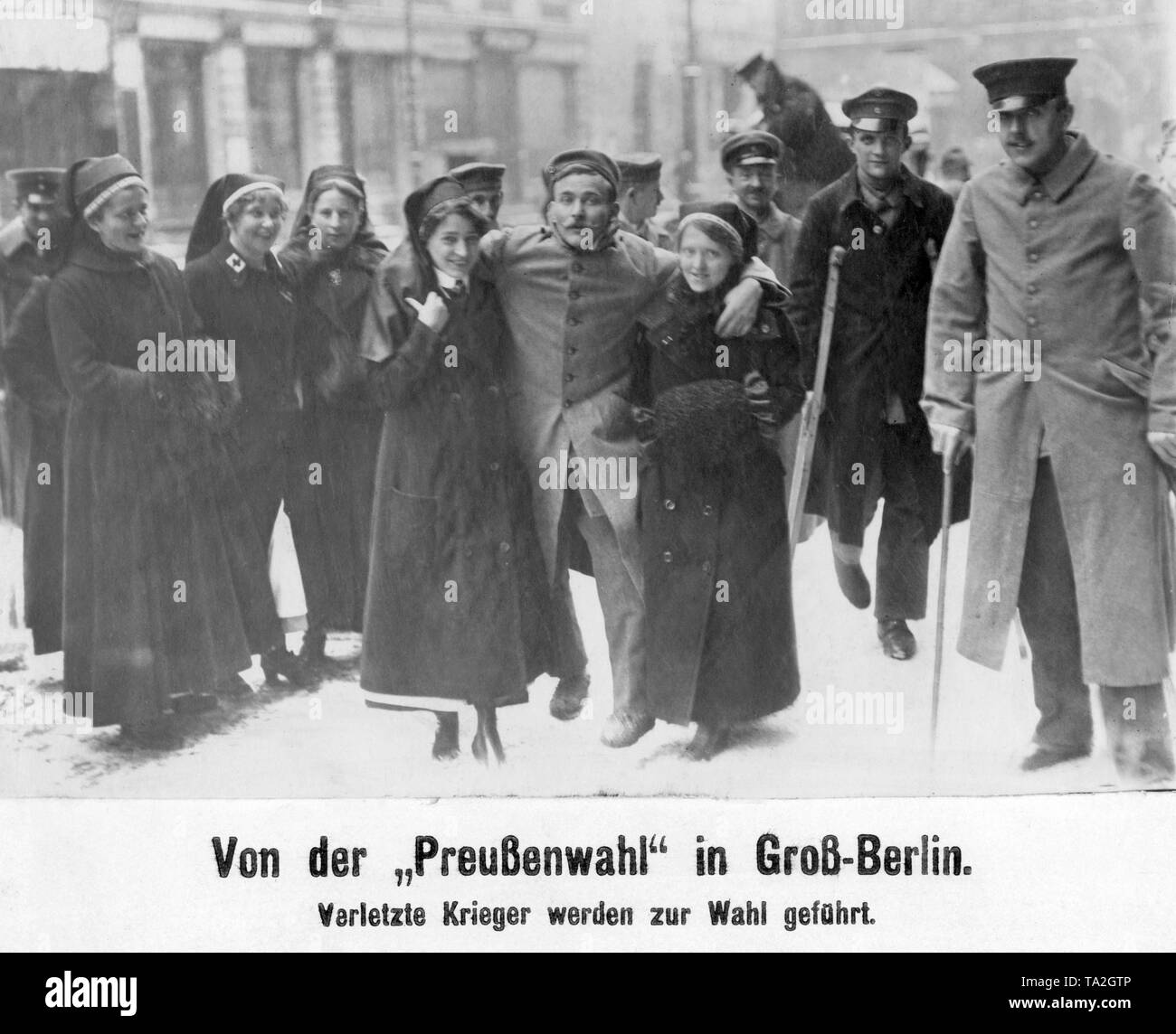 I soldati feriti sono guidati dalle suore per la stazione di polling a Berlino. Foto Stock