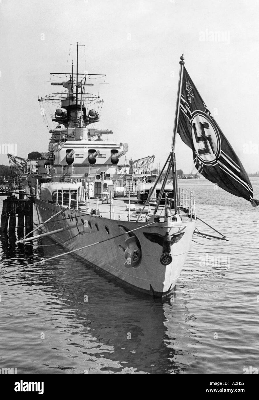Foto della parte posteriore dell'incrociatore pesante 'Deutschland' alla grande revisione navale a Swinoujscie (Polonia) presso la laguna di Stettino nel Mar Baltico. La nave è ancorata nel porto. Qui, l'aquila imperiale con una croce uncinata, nonché la naval ensign del Reich tedesco a poppa. Dietro la torretta posteriore con tre 28 cm quick-sparare cannoni. Foto Stock