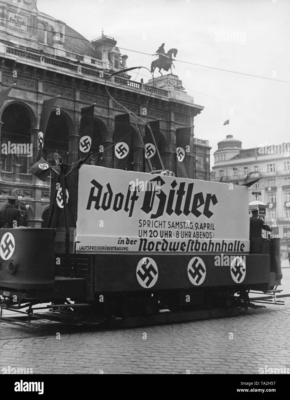 Dopo l'invasione delle truppe tedesche in Austria un referendum è in procinto di essere tenuto su l'annessione dell'Austria per il Reich tedesco. Un tram auto attraverso unità di Vienna con un cartellone. Il consiglio di amministrazione si legge "Adolf Hitler terrà un discorso sul Sabato 9 Aprile a 20 o'clock (8 pm) in Nordwestbahnhalle'. Foto Stock
