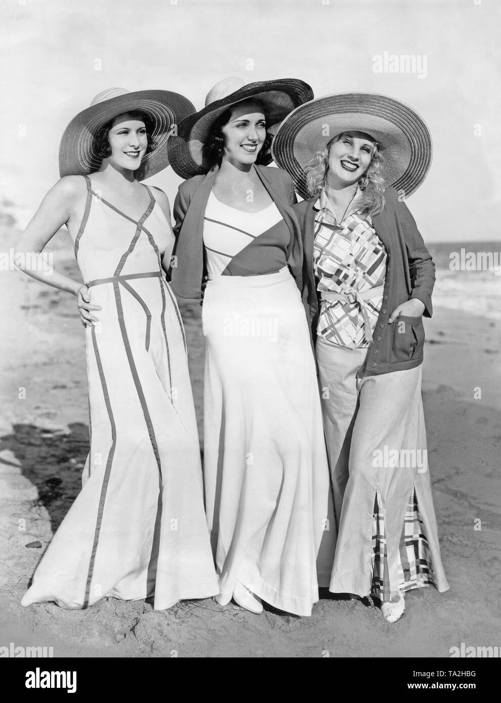 Le attrici Frances Dee, Adrienne Ames e Judith pongono in legno sulla  spiaggia con grandi cappelli Foto stock - Alamy