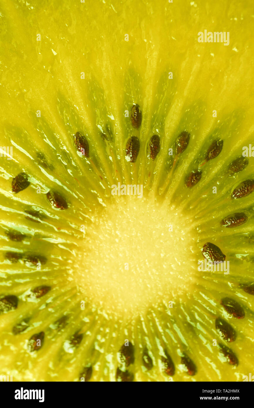 L'immagine verticale di Kiwi Sezione in colore giallo per lo sfondo Foto Stock