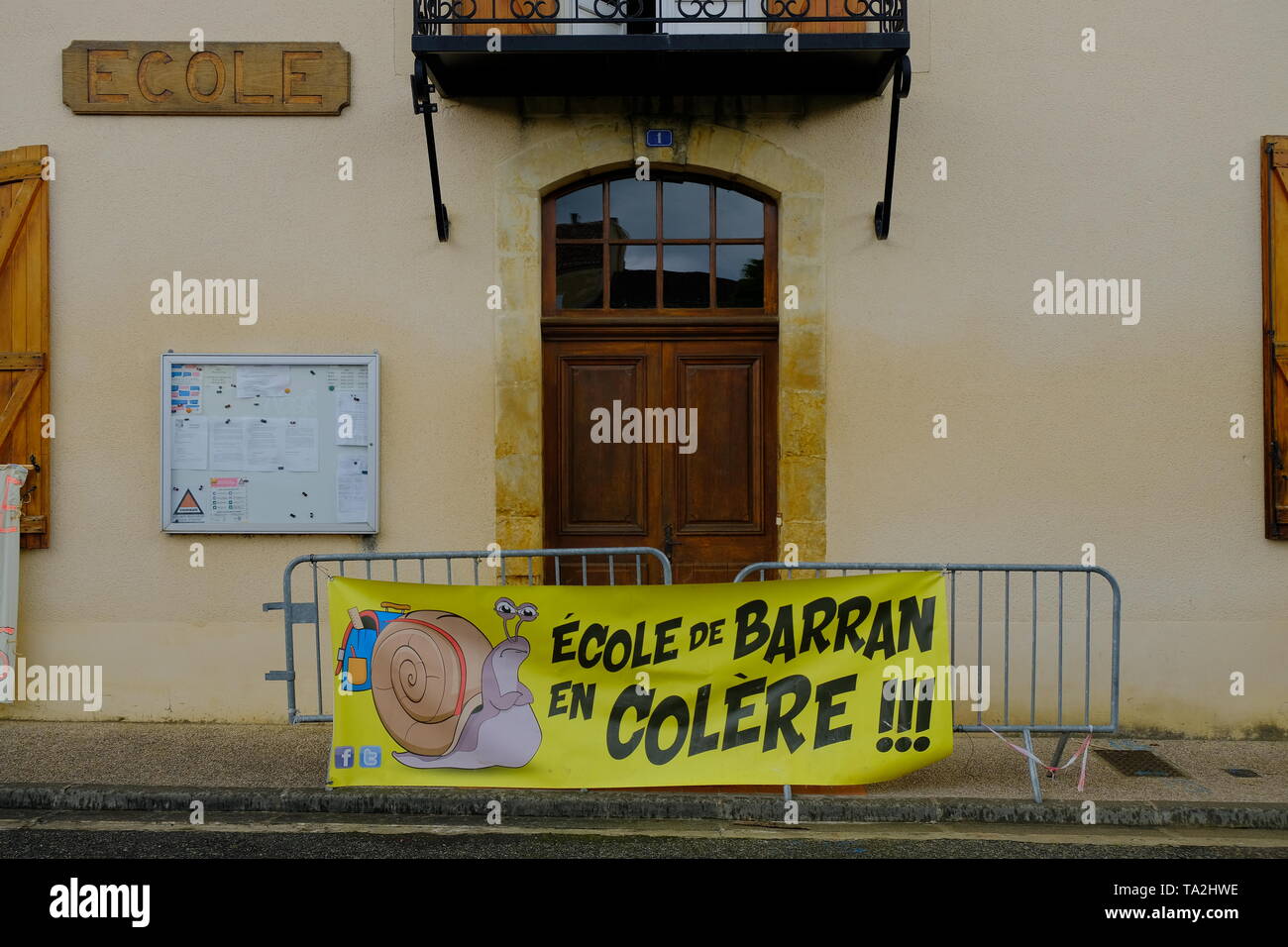 Banner e barricate nella parte anteriore della porta della scuola per protestare contro la chiusura di una classe quattro della scuola del villaggio, in Barran, Francia, Maggio 2019 Foto Stock