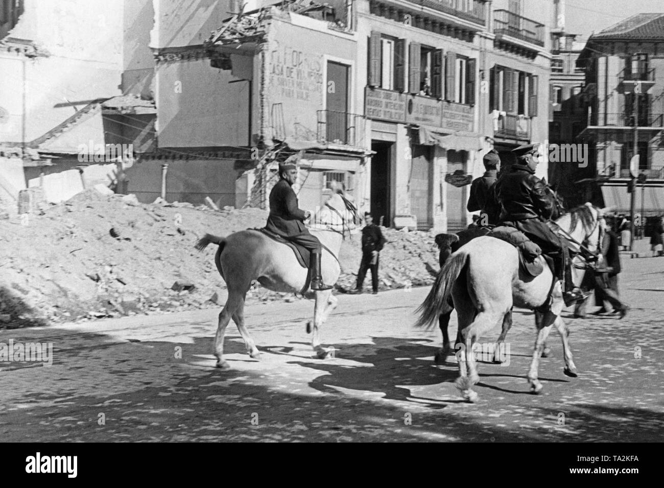 Foto di tre ufficiali a cavallo per le strade di Malaga. Secondo da destra, metà nascosta: Francisco de Borbon y de la Torre, duca di Siviglia (1882 al 1953) 1937. Sullo sfondo una casa, presumibilmente distrutta da bombshells. Foto Stock